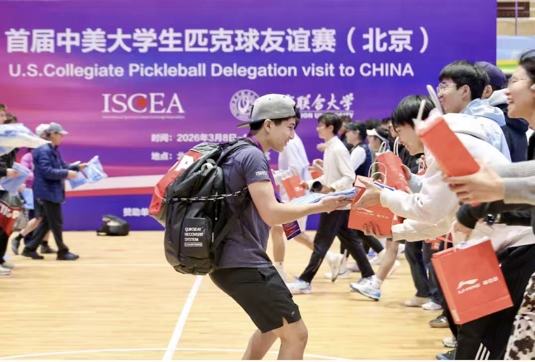 Student-athlete greeting participants during the Beijing event